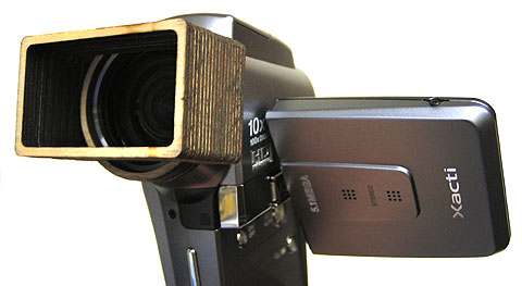 Xacti VPC-HD1  with accessory lenshood  - this lenshood fits snugly on the camera and provide protection from sunlight. Please note that the lenshood is cut for widescreen use, it will show up in still images.